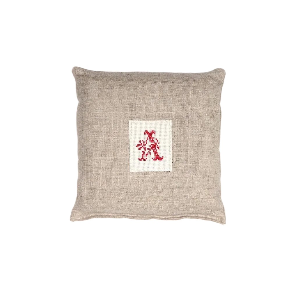 A beige linen lavender bag with a red embroidered initial.