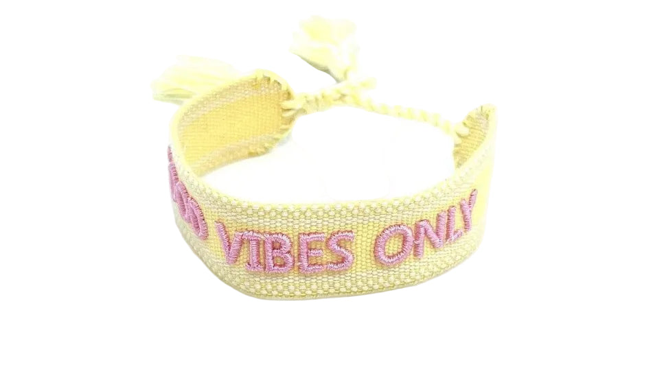 Yellow bracelet with pink text on a white background