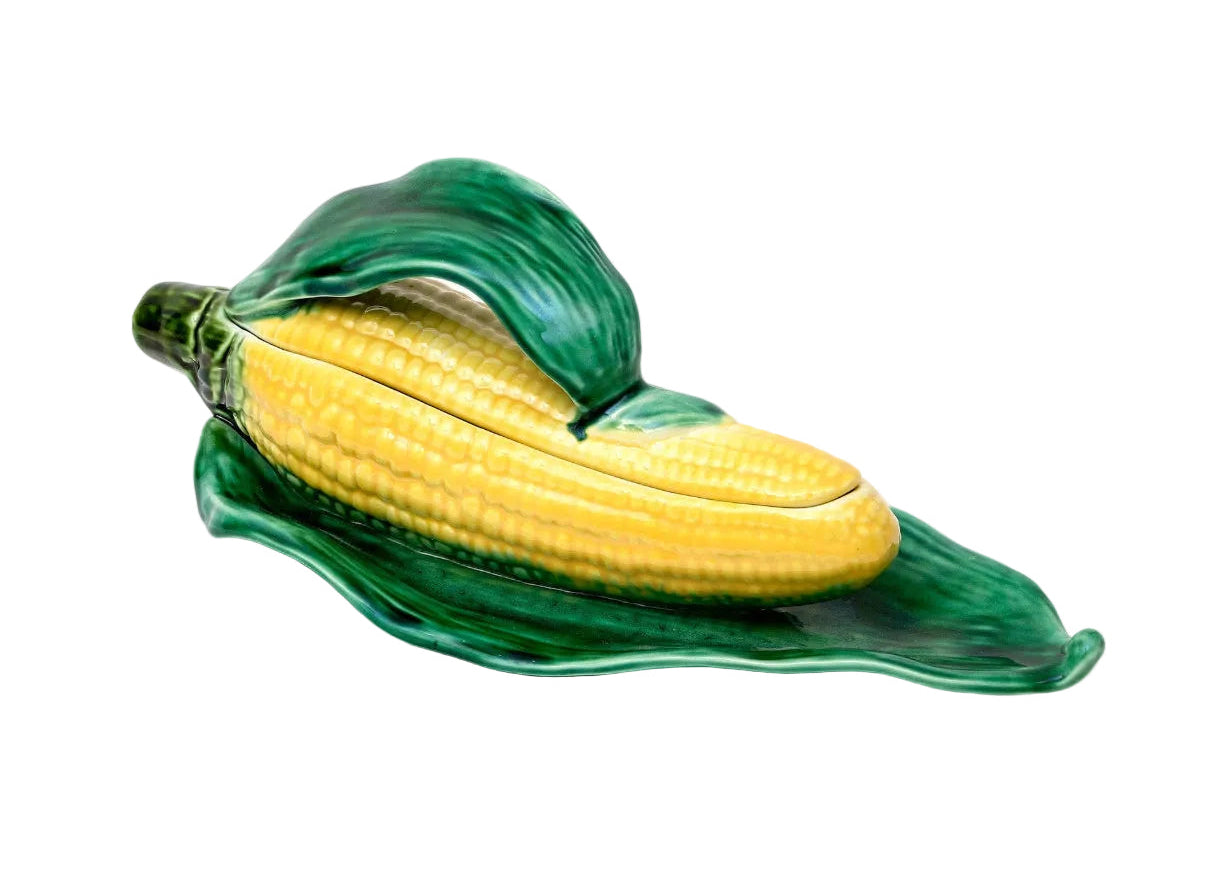 Ceramic corn on the cob dish with green leaves on a white background