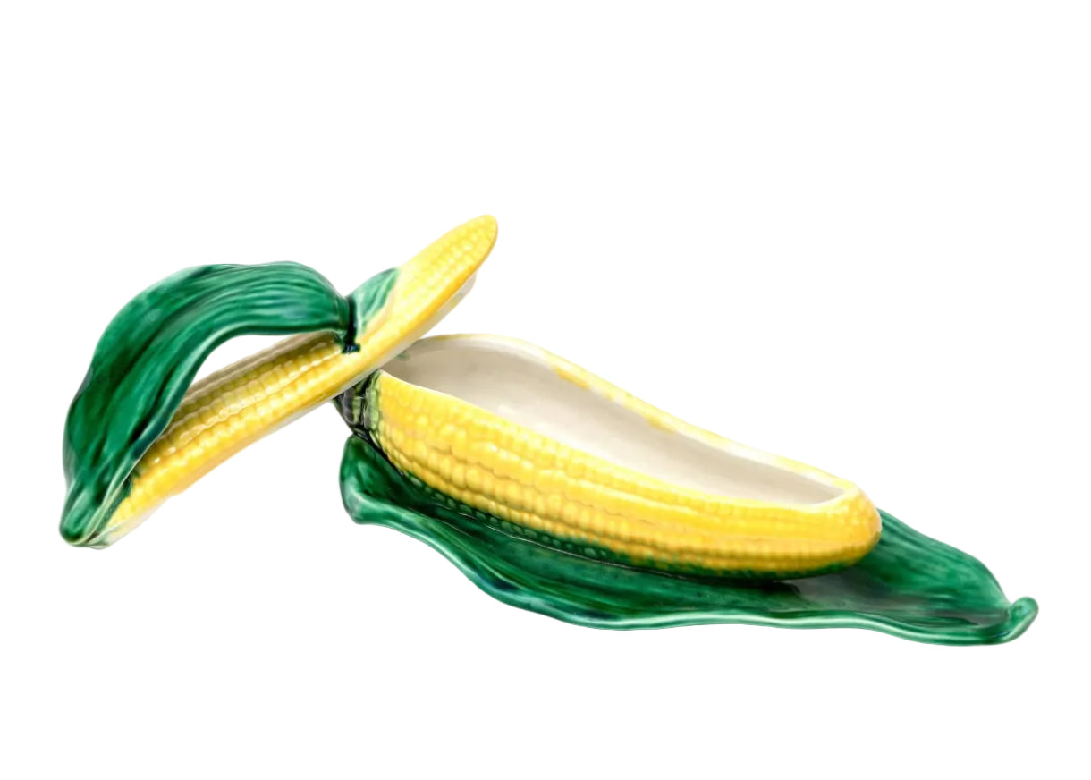 Ceramic corn on the cob dish with green leaves on a white background