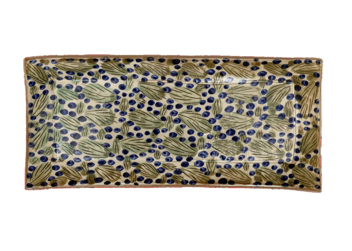 Decorative rectangular plate with leaf pattern on a green background