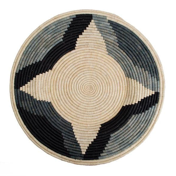 A round, handwoven raffia basket with geometric patterns in gray, black, and beige colors, intended for wall decoration.