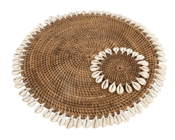 Round woven placemat with shell decorations on a white background