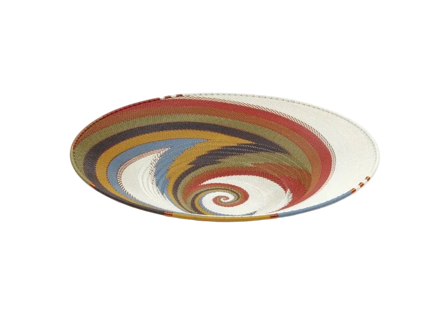 A hand-woven basket made from telephone wire in shades of yellow, greens, and browns, with a round shape and flat base, displayed against a white background.